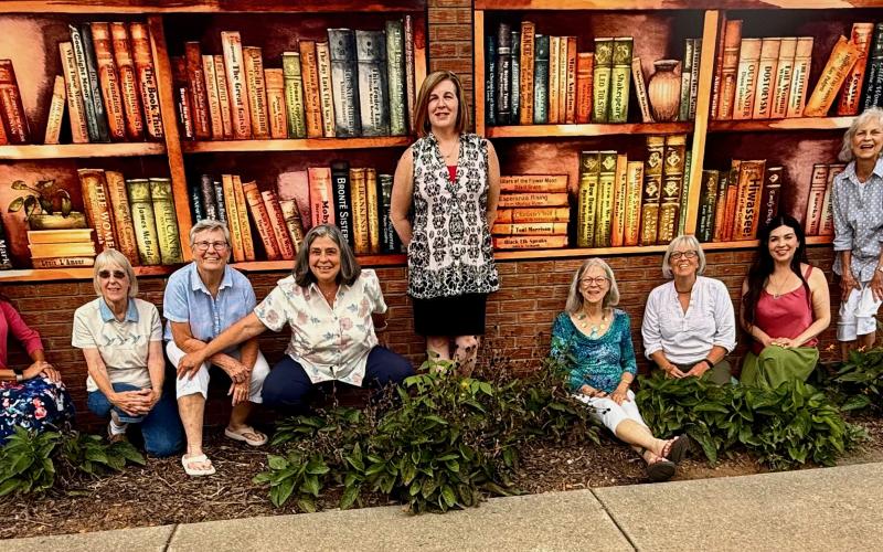 Jennifer Johnson • Moss Memorial Library Friends of the Library Board, from left, are Mary Anne Koos, Marcy Fuerch, Melinda Bradley, Darcy Gerrand, Kat Whitmer, Misty Rutherford, Olivia Anderson, Terry Penland, Amanda Wesson, Dorothy Ethridge and Gwen Christian. Friends admire the new mural on the back wall of Moss Memorial Library.