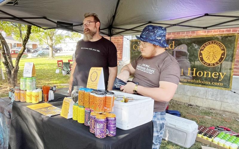 Deby Jo Ferguson • Clay County Progress From left, Ted Dunham and Gabe Smith, of Wherloom Honey &amp; Meadery of Robbinsville, gave information for their unique honey products to those who tasted mead for the first time at last  years event.