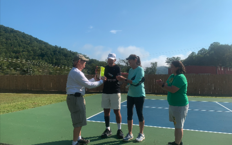 Stecoah Valley Center Board Chair Board Rick Davis presented Patriot Day Pickleball Tournament winners Randy and Shelley Conklin with pickles, pickleballs and Appalachian Roadshow tickets. Also pictured was Karen McCracken, Stecoah Valley Center Program Director and tournament organizer.