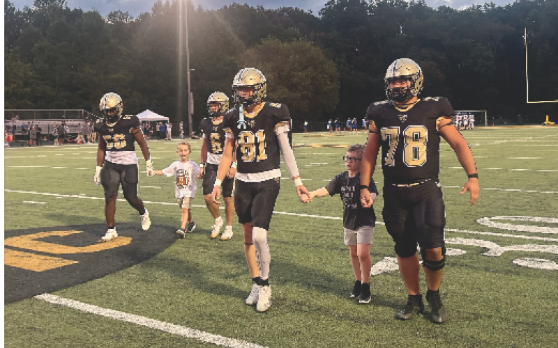 Gracie Taylor • Clay County Progress Varsity Jackets escort Rhet Lovingood and Cooper Godfrey onto the field Friday evening during Youth Night at Frank R. Long Memorial Stadium. From left are Will Brown, Lovingood, Tre Graves, Jameson Dawson, Godfrey and Rayland Martinez