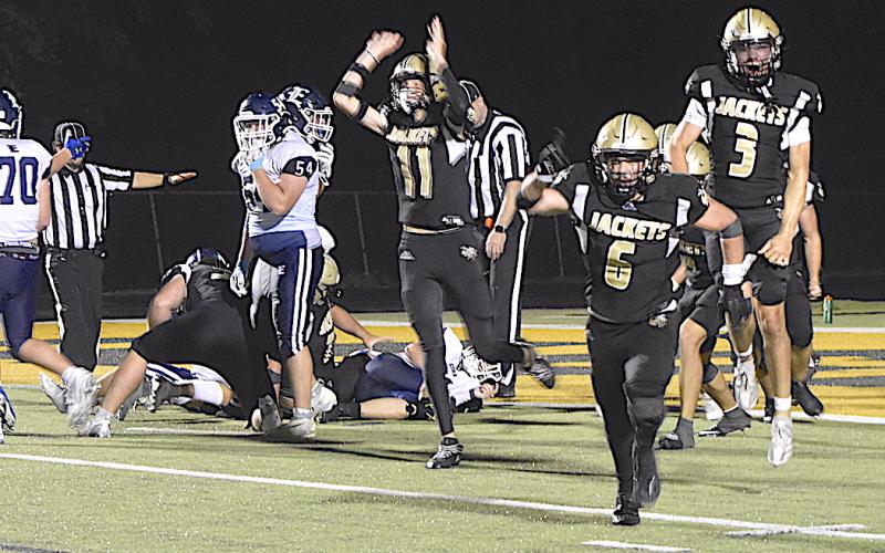 Gary Corsair • Clay County Progress Yellow Jacket defenders Donivin Soto, No. 11, Tre Graves, No. 6 and Colton Bruggers, No. 3, celebrate their victory-clinching goal line stand that foiled Enka's two-point conversion attempt with :43.7 left to play.