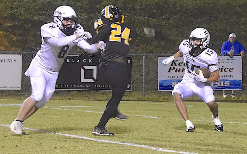 Photo by Gary Corsair Elio Murillo, No. 15, jukes a Murphy defender as he breaks a 28-yard kickoff return for Hayesville’s longest gain of the night. That’s Brett Hanna, No. 8, throwing the block.