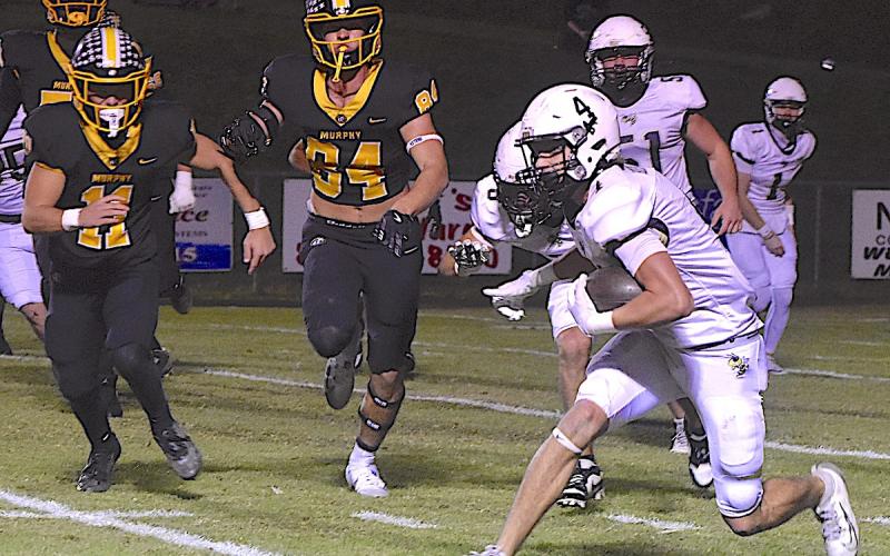 Photo by Gary Corsair Hayesville’s Ben Bethel, No. 4, busts a move after gathering a short pass from Peyton McGaha, No.1. Brendon Collins, No. 51, watches as Ryland Graves, No. 9, looks a Bulldog to hit as Bethel veers outside.