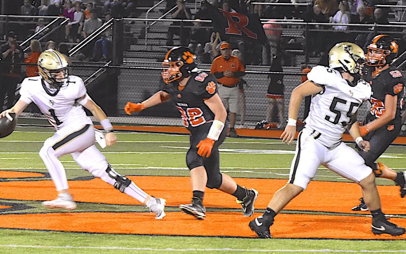 Gary Corsair • Clay County Progress Hayesville quarterback Peyton McGaha, No. 1, eludes a Rosman defender by scrambling out of the pocket as Matt Gorham, No. 55, looks for another intruder to block. McGaha turned the crisis into triumph by firing a pass to Tre Graves, who raced down field and scored a touchdown.