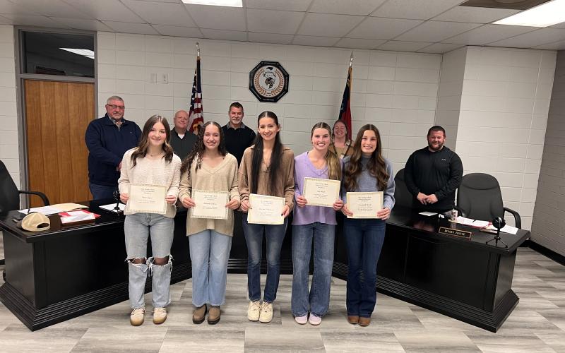 Angel Owens • Photo Clay County Schools Board of Education recognized five young women in fall sports, from left, Reese Segars, Aaliyah Jackson, Grayson Williamson, Ave Shook and Savannah Burch received awards in women's volleyball; back, from left, board members Danny Jones, Robert Caldwell, Chairman Jason Shook, Superintendent Melissa Godfrey and Board Member Josh Ashe.