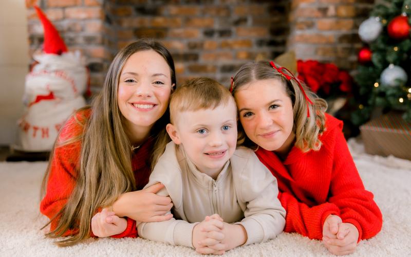Photo contributed Cooper Godfrey, 7, poses for a Christmas photo with his older sisters, 14-year-old Annie on left, and 12-year-old Allie.