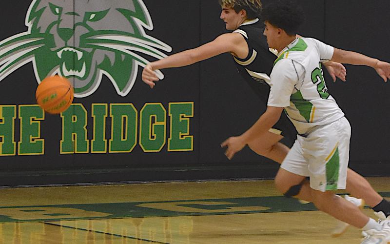 Gary Corsair • Clay County Progress Hayesville's Damien Soto, No. 4, wins the race to retrieve a loose ball at Blue Ridge Early College.