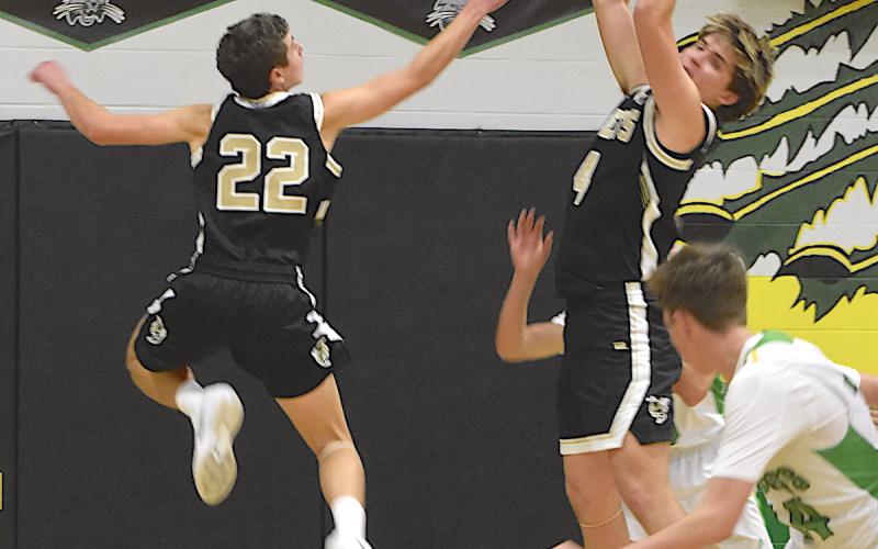 Gary Corsair • Clay County Progress Yellow Jackets guard Eli Cheeks, No. 22, soars through the air as teammate Daemien Soto, No. 4, snares a rebound.