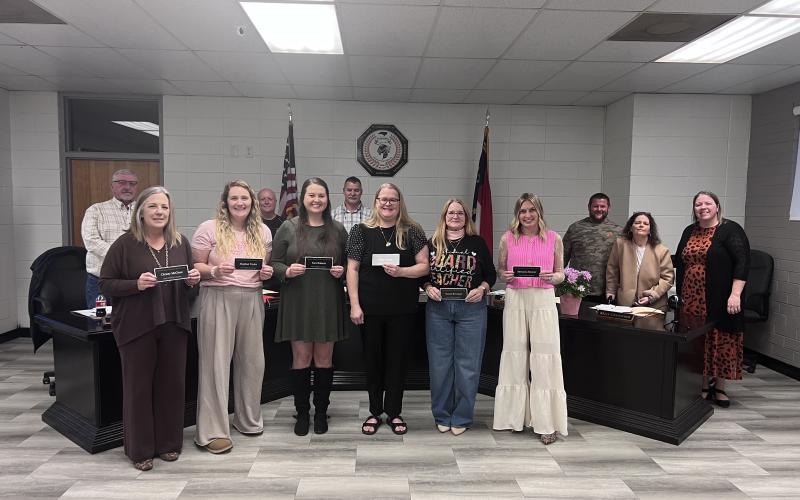 Angel Owens • Photo Newly National Board Certified teachers, front, from left, Christy McClure, third grade; Meghan Taylor, second grade; Tara Roberts, second grade; Katie Danner, third grade; Susan Rexroad, third grade and Adrianna Deaver, second grade were recognized at the Board of Education meeting. Board members, back, from left, Danny Jones, Robert Caldwell, Chairman Jason Shook, Josh Ashe, Kelly Crawford and Superintendent Melissa Godfrey congratulate the teachers.