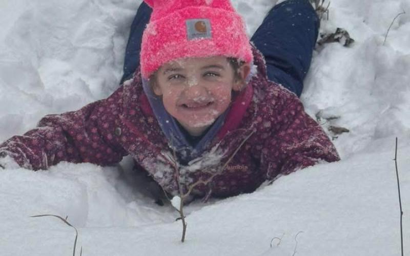 Who needs a sled when you can just get a run and go? Rowen Lovingood is all smiles covered in snow.