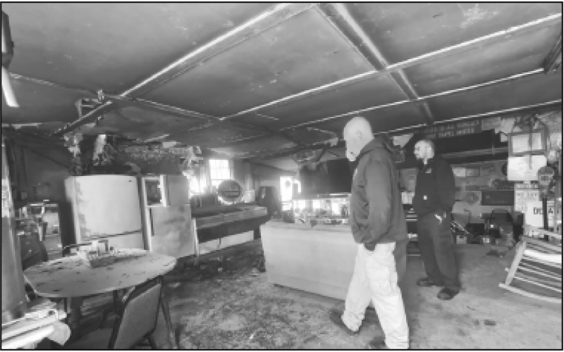 Randy Foster/editor@cherokeescout.com Clay County Fire Chief Brian Henderson, left, takes a phone call as assistant fire chief Chris Denton stands by inside Clay’s Corner, which was damaged in a fire Friday afternoon.