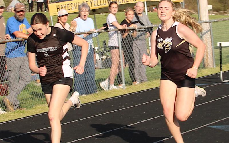 Neal Wachob• Clay County Progress Hayesville's Marlo Joyce,right, give her all in a near photo finish in the 300-meter hurdles. Joyce finished just :00.28 behind the winner.