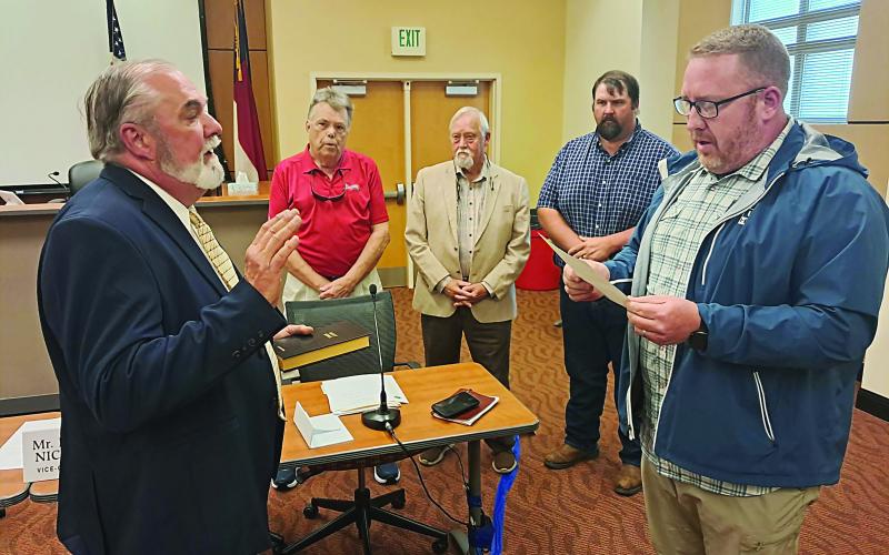 Becky Long • Clay County Progress William “Bill” Carter receives the oath of office from County Commission Board Chairman Rob Peck as commissioners, from left, Scotty Penland, Clay Logan and Randy Nichols observe. April 2 was Carter’s first meeting in his official capacity of commissioner.