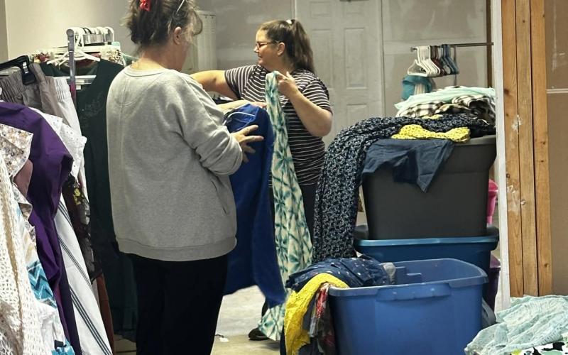 Lorrie Ross • Clay County Progress Lori Allen in foreground, checks some donated clothing as Jenny Jaya hangs dresses on a rack. Jaya said this was her first time volunteering with the clothing ministry and she really enjoys it.