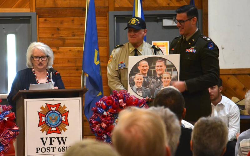 Active service member Reid Woody receives recognition for his family's service from Betty Bradley and Post Commander John Clodfelter.