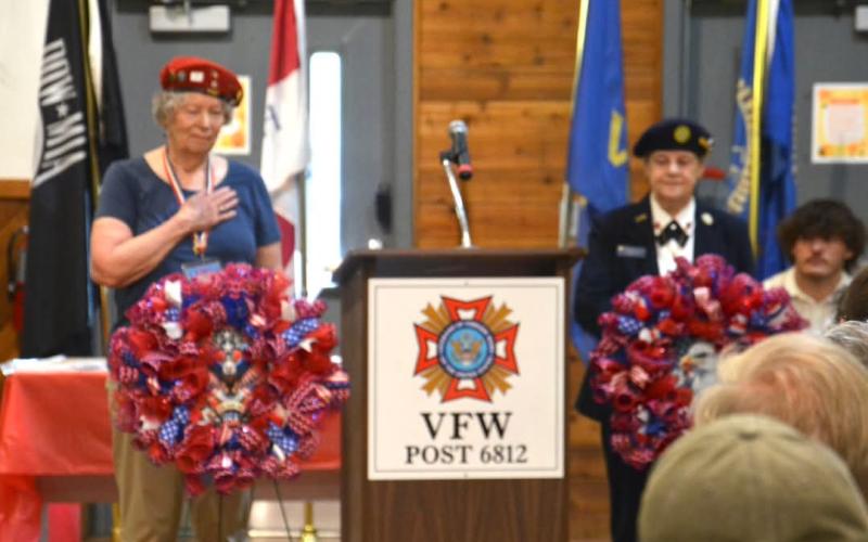 VFW Auxiliary President Helen Davis and American Legion Auxiliary President Teresa McClure place the wreaths.