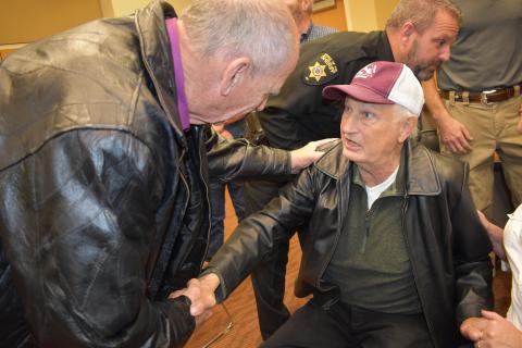 (Becky Long • Clay County Progress) Former sheriff Tony Woody receives congratulations from former sheriff, Vic Davis.