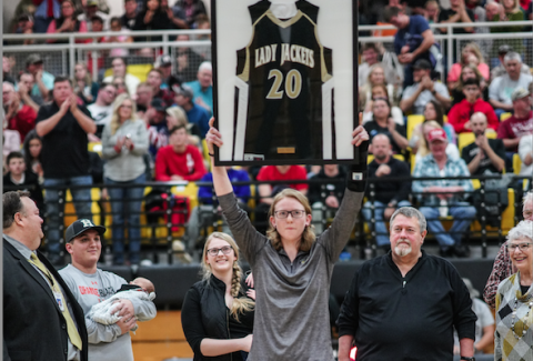 (Kelli Graves • Clay County Progress) Former Lady Yellow Jacket Amanda Thompson holds her now retired No. 20 high in front of a packed gym as her family looks on with smiles.