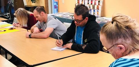 From left, Kristi and Darren Cook and Steven Donaldson take notes for an activity during the Community Café.