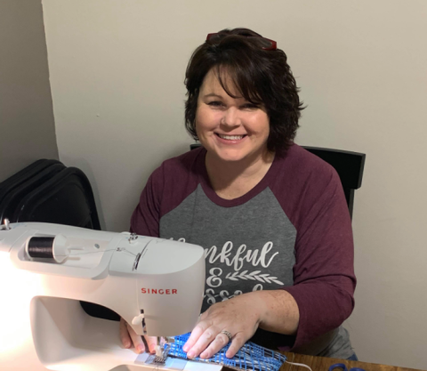Jennifer Carter sits at her newly acquired sewing machine making masks to distribute to the community.