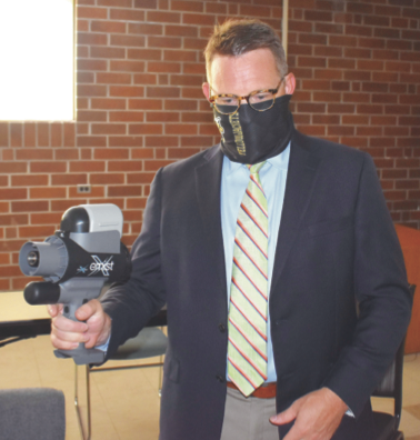 (Travis Dockery • Clay County Progress) Superintendent Dole Cole demonstrates how custodians will use the mister to make sure every inch of a room is protected.