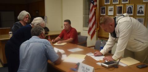 (Becky Long • Clay County Progress) County attorney Merinda Woody and administrator Betty Bradley wait for commissioners’ Dwight Penland, Scotty Penland and Rob Peck, along with Randy Nichols, not shown, to sign resolutions following the Oct. 1 county commission meeting. Commissioner Clay Logan was not present.