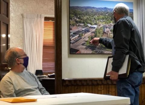 (Lorrie Ross • Clay County Progress) CCCRA representative Paul Price points to the aerial photo of Hayesville to show where the organization wants to place a new sign for the Beal Center.