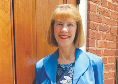 (Marcia Barnes • Clay County Progress) Standing beside the courthouse door, Brenda Kay Ledford holds her new children’s book “The Singing Convention” from where it all took place.