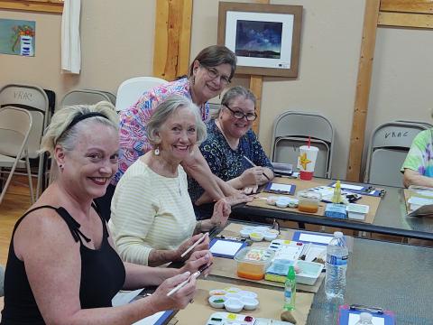 Students work on their water color technique at a recent class.