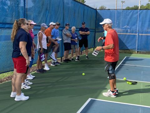 Harry Jarrett leads a group of ten new area pickleball players during an August skill clinic held at the Clay County Sports Complex.