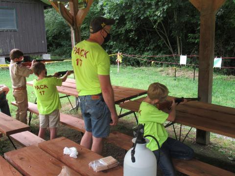 a Cub Scout pack takes aim during a BB gun target event.