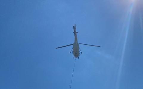 Trevis Hicks/Contributing Photographer A helicopter with the National Transportation Safety Board flies in wreckage from the Oct. 3 plane crash to Western Carolina Regional Airport on Friday.