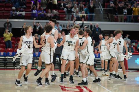 (Kelli Graves • Clay County Progress) The Yellow Jackets swarm the William Neal Reynolds Coliseum court to celebrate their 1A state championship win over Chatum Charter. After being down by as many as 11 points, Hayesville rallied to force overtime. The extra period saw the Jackets pull away to win 54-43.