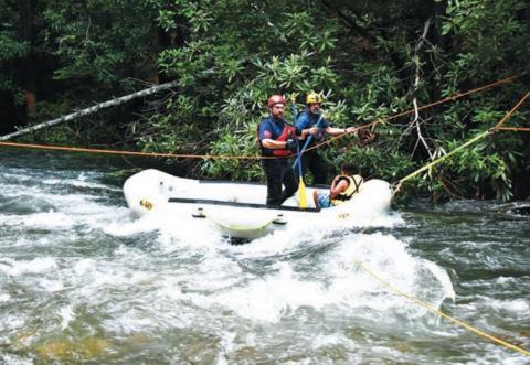 Joe Davenport • Clay County Progress A Valley Town Swift Water Rescue team member and Clay County Fire & Rescue’s Tim Noland  transport a young boy who had been stranded back to the safety of dry ground