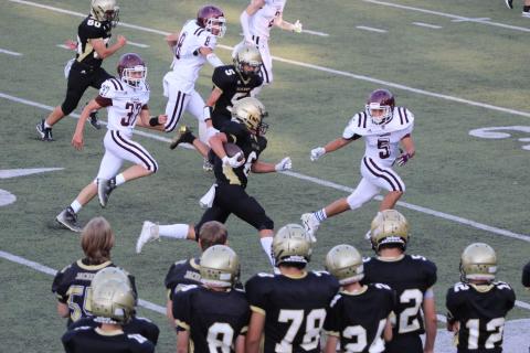 Photo by Kendra Coker JV Jacket Tre Graves runs through a tight defense for a first down.