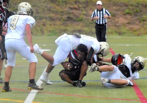 Gary Corsair • Clay County Progress North Georgia's quarterback loses his helmet during a bone crushing tackle by Yellow Jackets Jeremy Graves, No. 51, and Cameron Payne as teammate Seth Leek, No. 9, looks on.