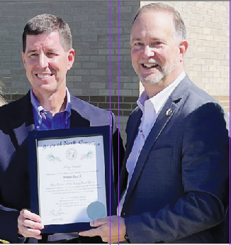 Kevin Hensley • Graham Star Retired Department of Transportation engineer Brian Burch receives a certificate marking his membership in the Order of the Long Leaf Pine by N.C. Department of Transportation Secretary Eric Boyette, following a highway project groundbreaking ceremony at Robbinsville High School on Monday. The Order of the Long Leaf Pine is among the most prestigious awards presented by the governor of North Carolina.
