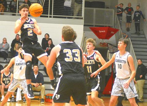 Gary Corsair • Clay County Progress Hayesville's Logan Caldwell, No. 2, splits the Robbinsville defense and dishes to Kyle Lunsford, No. 33, as Isaac Chandler, No. 11, boxes out.