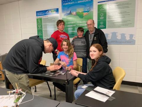 Hayesville Middle School members of the Fly Fishing Club watched as Jesse Shook, left, demonstrates fly making. Hawk Collins, center and Emily Lyvers on the right watch.  Standing, Ernie Taylor, Matthew Terry and Greg Charles, club leader.