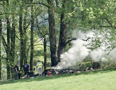 Emergency responders assemble beside the burning wreckage of a Velocity airplane that crashed shortly after takeoff from Western Carolina Regional Airport on Saturday morning.
