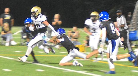 Gary Corsair • Clay County Progress Taylor McClure, No. 20, hurdles two defenders on the way to a 20-yard touchdown run after zipping through a hole opened by Hayesville's hard-working offensive line. McClure led the Yellow Jackets potent offense with 122 yards rushing.