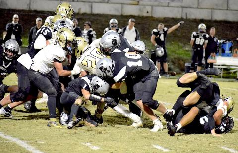 Photo by Jenny Collins Millsaps Hayesville's Taylor McClure, No. 20, fights to gain a first down on a crucial fourth-and-one carry. McClure's momentum appears to carry him to the desired destination, the short hash mark closest to the long line at the bottom of the photo, but officials ruled that McClure came up short and awarded the ball to Robbinsville.