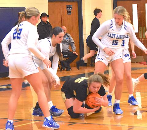 Gary Corsair • Clay County Progress Hayesville’s Mallory Peck smoothers the ball as four out of five Lady Eagles converge on her.