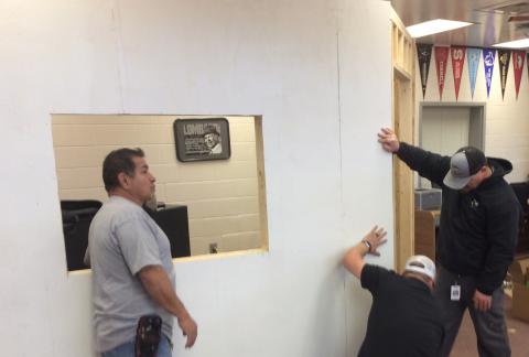 Adam Sanchez, Chris Lange and Steve Lyvers work on the underground school store front.
