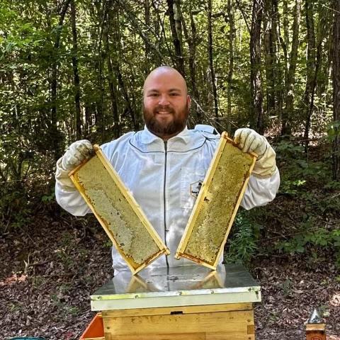 Branson Worley with his beehives carrying on a family tradition and his dream.