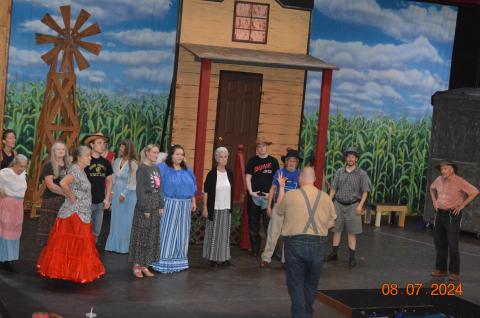 Photo by Pam Roman The “Oklahoma!” cast and ensemble are, from left, by windmill, Teresa Lemaire, Leslie Richardson, Leta Reeves, Mikey Lindsey and Janice Lessard; front row, Natalie Schaible, Hope Ledford, Carli LeJeune, Patty Carreau, Alex Giles, Joe Zang, Harrison Keely and Paul Keely; back to camera, Cameron LeJeune, warm up.