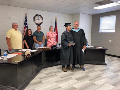Marcia Barnes • Clay County Progress Board members Danny Jones, Kelly Crawford, Jason Shook and Superintendent Melissa Godfrey recognize Santiago Renteria Mendoza as he receives his diploma from Hayesville High School Principal Stacey Overlin.