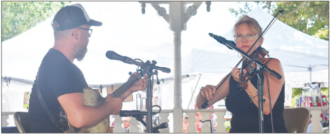 Becky Long • Clay County Progress Lindsey Liden and sister Emolyn Liden tune up the Festival on the Square Sunday with unique, old-time music which is a family tradition for them. The festival is sponsored by Clay County Historical and Arts Council. It drew a large crowd on Saturday and was a little more subdued on Sunday which is usually the case. Vendors reported good sales and attendees reported delicious food and by all accounts everyone was grateful for the sunny, albeit hot weather.