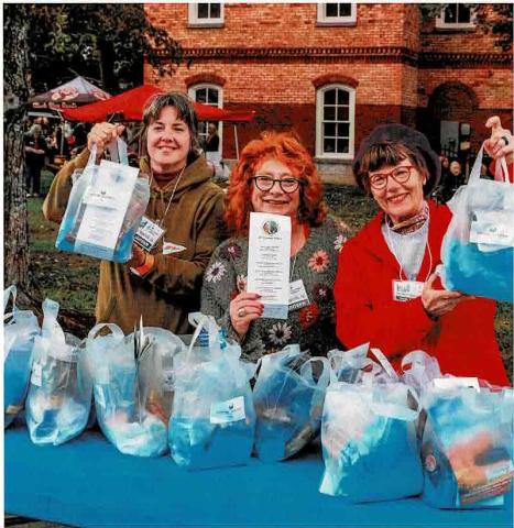 From left, HHI volunteers Misti Muscat, Lynne Maniotes and Wendy Slaton provided attendees packets at a previous Steins & Wine event. The bags are available at the entry gate with information about vendors and supporters.
