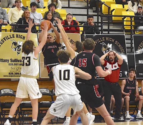 Gary Corsair • Clay County Progress Yellow Jackets Jackson Sellers, No. 33, and Brady Reynolds, No. 14, defend Andrews potential game-winning shot at the buzzer of regulation as Wildcats Coach Matt Maennle hopes for a miraculous 3. Hayesville's Brenden Lynch, No. 10, is also on the scene.